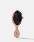 MIKAH Mini Hairbrush Pink with flexible nylon bristles on a white background