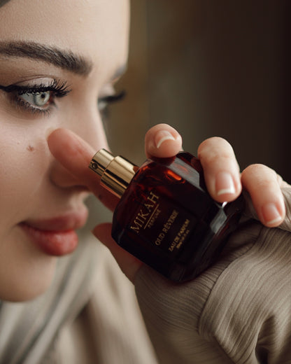 Woman applying MIKAH Oud Rêverie perfume in a beauty routine